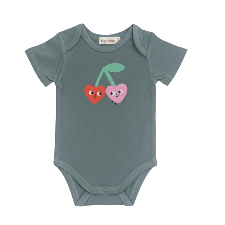 Green baby onesie with cherry heart design on a white background