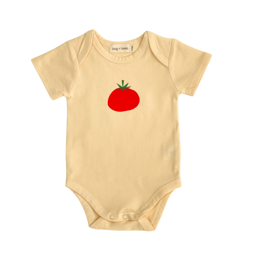 Yellow baby onesie with a red tomato design on a white background