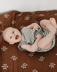 baby laying on cotton muslin quilt, chestnut textiles